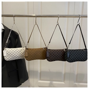 Detail view of four baguette bags with letter prints and branded hangtags on a rack