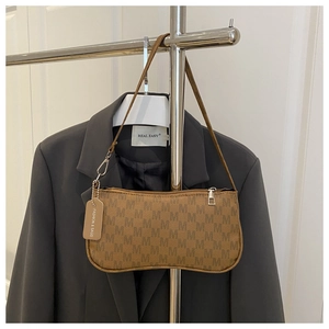 Detail of brown monogram underarm bag with silver zipper on a grey blazer hanger