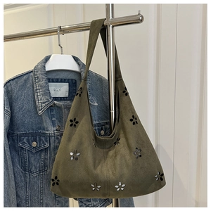 Close-up of olive green hobo bag featuring intricate laser-cut floral patterns and texture