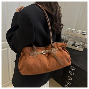 Detailed view of caramel brown suede tote bag with leather straps and metal buckle