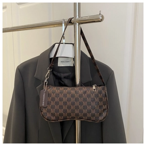 Macro shot of brown coffee monogram shoulder bag with metallic zipper and fashion tag
