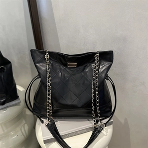 Quilted black leather tote bag with gold chain straps and vintage diamond pattern