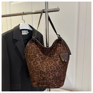 Macro shot of large leopard print tote bag with brown faux suede texture and leather strap