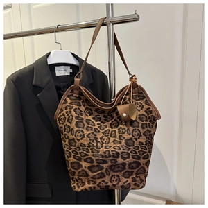 Close-up of leopard print tote bag with brown leather trim and large capacity design