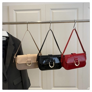 Three glossy patent leather shoulder bags in beige black and red with gold D-ring hardware