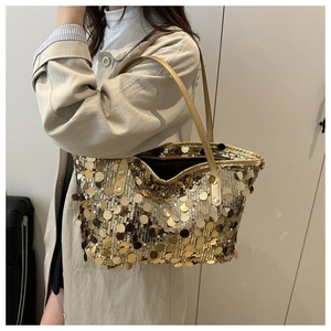 Close-up detail of golden sequins and slim leather strap on a large tote bag