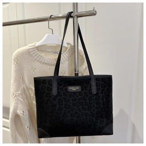 Detail of vintage leopard print tote bag featuring a branded label and reinforced corners