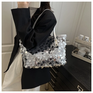 Close-up of silver sequin tote bag with metallic texture and sleek shoulder strap detail
