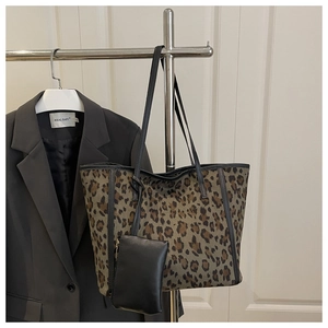 Dettaglio borsa shopper leopardata con piccolo astuccio coordinato in pelle nera appeso