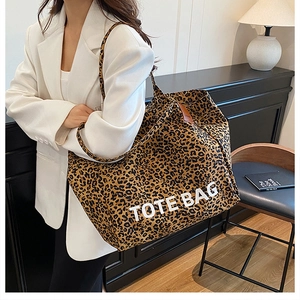 Detailed close-up of a large leopard print tote bag styled with a white blazer and long skirt