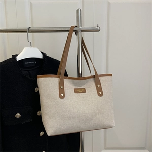 Minimalist beige canvas tote bag with brown leather handles and CAHRES & HEXA logo