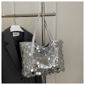 Detail of silver oversized sequins on a chic tote bag with metallic reflection