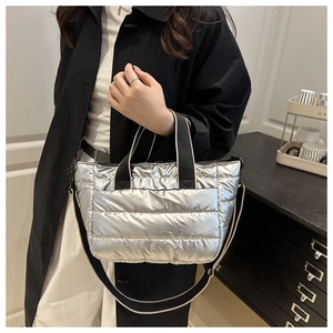 Borsa tote trapuntata argento con manici neri indossata da una modella per il lavoro