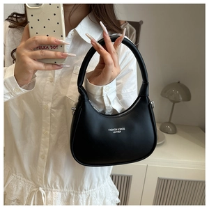 Close-up of black matte leather dumpling bag with Fashion & Bags lettering detail