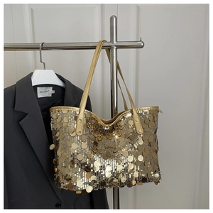 Detailed view of large gold sequins texture on an oversized fashion tote bag