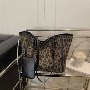 Retro leopard print tote bag with black trim and matching small pouch on a shelf