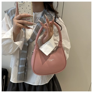 Detail of pink leather half-moon bag with embossed text and smooth zipper closure