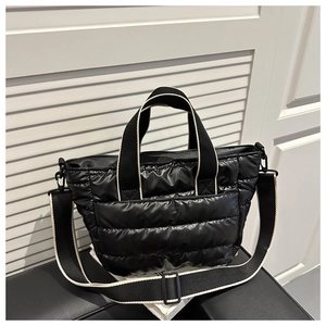 Dettaglio della borsa shopper nera trapuntata con bordi bianchi e tracolla rimovibile