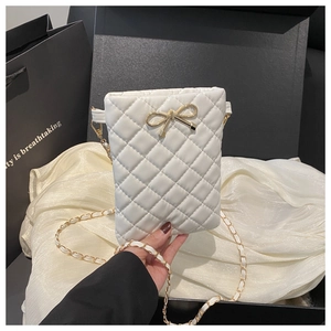 Détail du mini sac bandoulière blanc matelassé avec fermoir nœud doré et chaîne