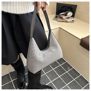 Detailansicht der grauen Hobo-Tasche mit Leopardenmuster, Logo-Prägung und breitem Schultergurt