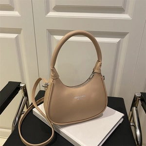 Chic beige crescent shoulder bag in premium vegan leather with elegant top handle and strap