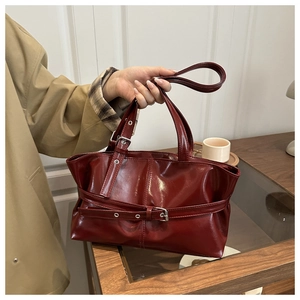 Dettaglio borsa shopper color vino con fibbia in metallo e finitura in pelle lucida