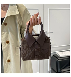 Close-up of shirt-style handbag detailing collar, buttons and vintage brown texture