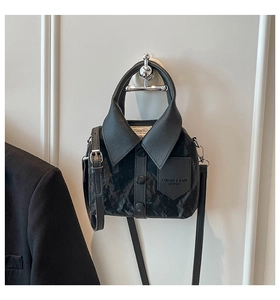 Detail of creative shirt-shaped black leather handbag with collar and button accents