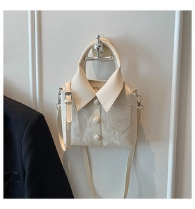Detail of cream-white handbag featuring shirt collar design and button accents