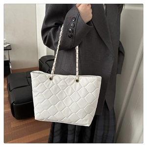 Detailaufnahme einer weißen gesteppten Shopper-Tasche mit goldener Gliederkette