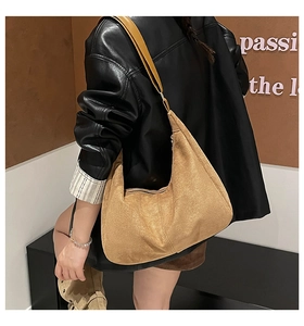 Bolso de hombro de ante camel de gran capacidad llevado por una modelo con chaqueta de cuero