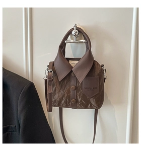 Close-up of brown shirt-shaped crossbody bag featuring collar and pocket details