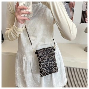 Detail view of leopard print crossbody phone bag with light gold chain strap texture