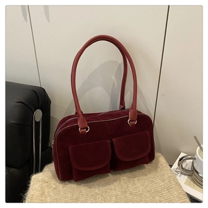 Détail du sac cabas bordeaux en daim avec poches avant à rabat et anneaux argentés