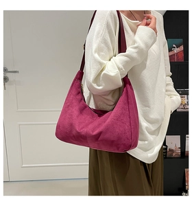 Detail of rose red suede hobo bag showing refined matte texture and metal zipper