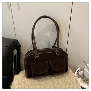 Détail du sac bandoulière en daim marron foncé avec deux poches avant rétro
