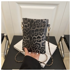 Detailed view of leopard print crossbody bag with gold metal chain strap and leather texture