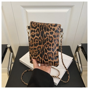 Close-up of leopard print phone bag with gold metal chain strap and soft texture