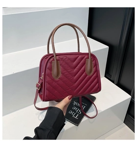 Vista dettagliata della borsa a conchiglia in pelle trapuntata bordeaux con fibbie d'oro