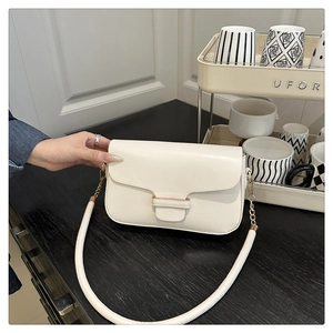 Detail of cream white leather flap shoulder bag with gold chain strap for women