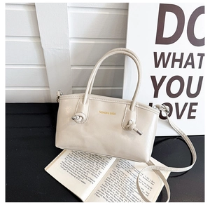 Detail of cream leather tote bag featuring rope knot handles and fashion logo print