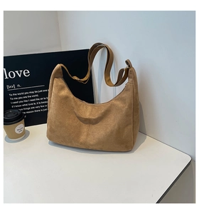 Detailed close-up of brown suede hobo bag with adjustable strap and stitching detail
