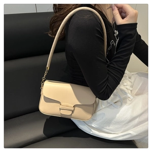 Detail of light beige crossbody bag with gold chain strap and leather buckle decoration