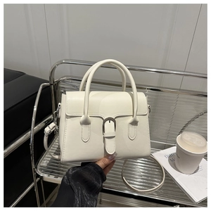 Detail of white minimalist faux leather handbag with adjustable strap and buckle decor