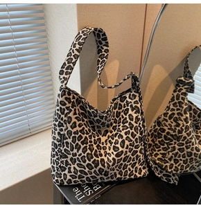 Detail of leopard print canvas tote bag featuring side fashion tag and hobo style shape