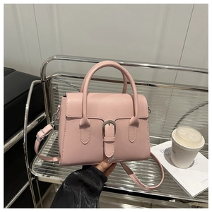Detailed macro of a light pink trapezoid handbag with silver buckle and smooth finish