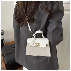 Crossbody mini bag in beige canvas and white leather shown on a grey blazer outfit