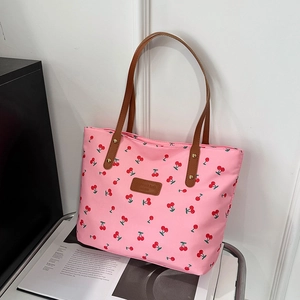 Grand sac cabas rose avec imprimé cerises et anses en cuir sur un chariot chic