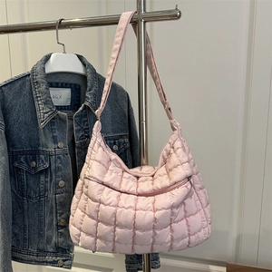 Quilted light pink shoulder bag with large checkered pattern and front zip pocket