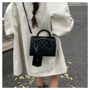 Détail du sac à bandoulière matelassé noir avec mini pochette assortie et dorures chics